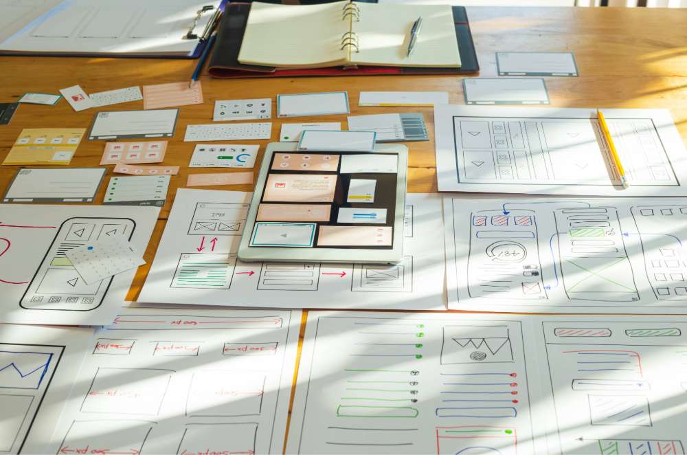 Series of diagrams and wireframes laid out on a conference table