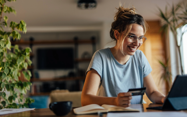 Woman on computer holding credit card