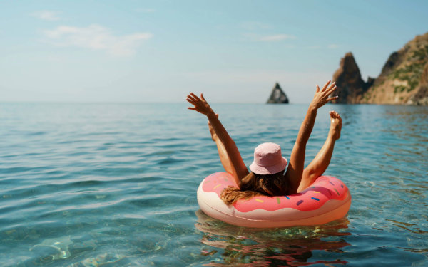 person on donut raft in ocean